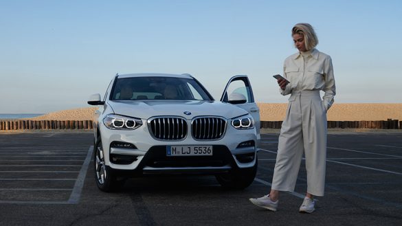 BMW X3 G01 Kataloge App Frau neben BMW 2021